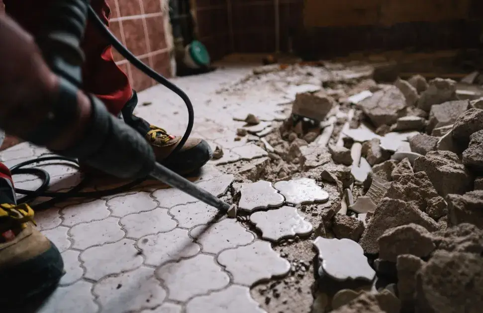 Demolición del pavimento antiguo con martillo eléctrico al inicio de la reforma de baño