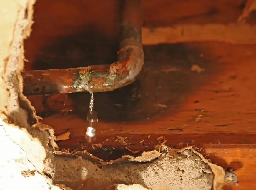 Tubería oxidada con fuga de agua activa causando daños por humedad en vivienda de Huelva