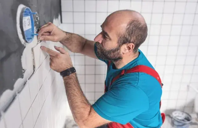 Colocación de azulejo de pared ajustado alrededor de una caja de mecanismo eléctrico en Huelva