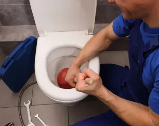 Operario realizando una reparación del hogar en el baño de una vivienda de Huelva