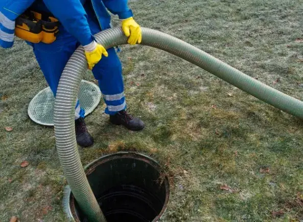 Operario revisando una arqueta de saneamiento en el exterior de una vivienda